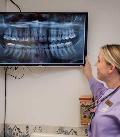 Team member looking at X ray on overhead monitor