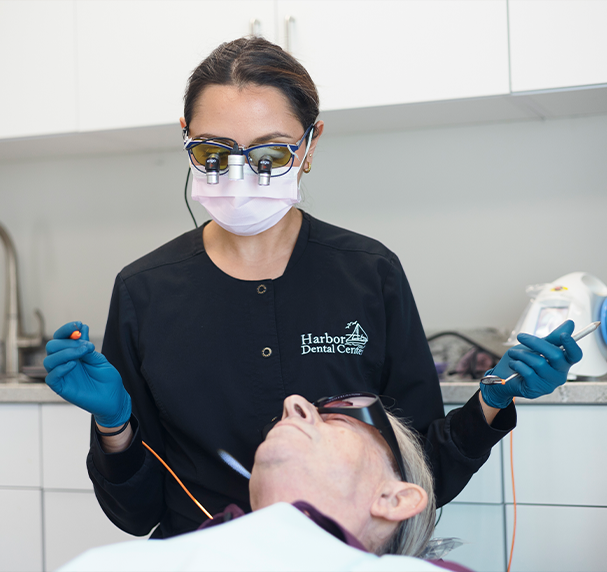 Team member with magnification glasses about to treat patient