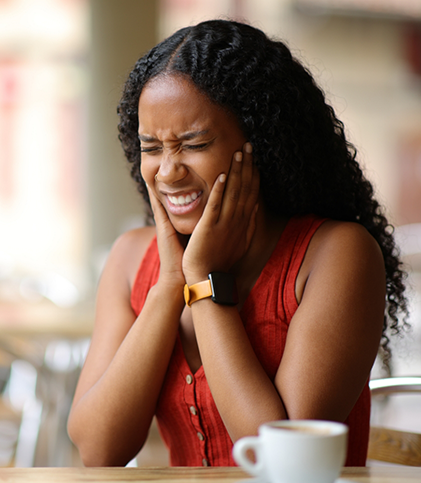 Woman sitting at table with toothache