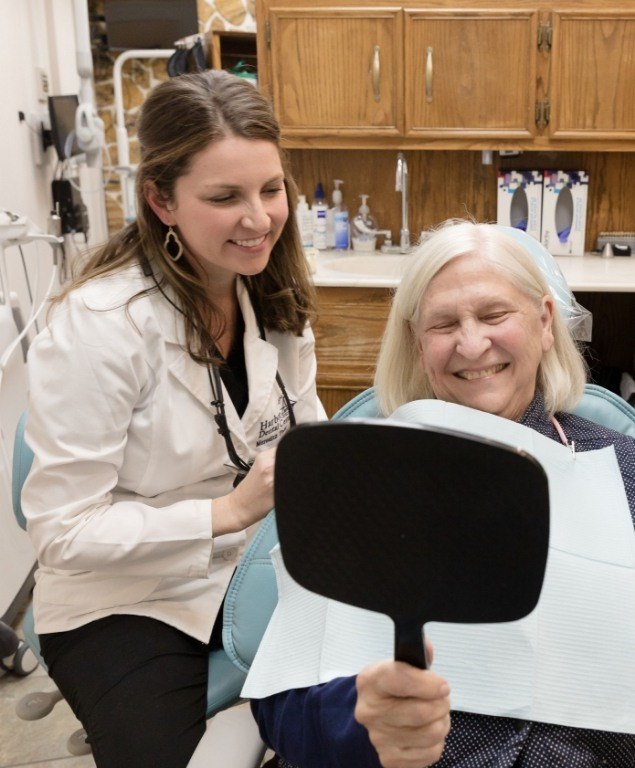 Cambridge dentist watching a patient see their new smile in a mirror