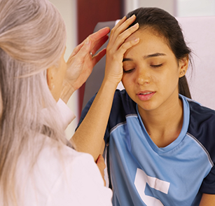 Young girl rubbing forehead while visiting doctor