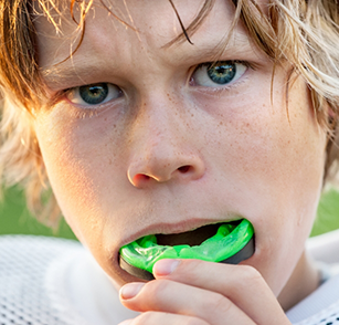 Young boy putting in an athletic mouthguard