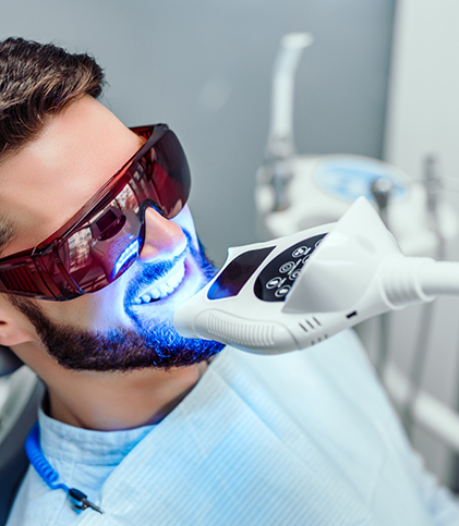 Close up of male patient during professional teeth whitening treatment