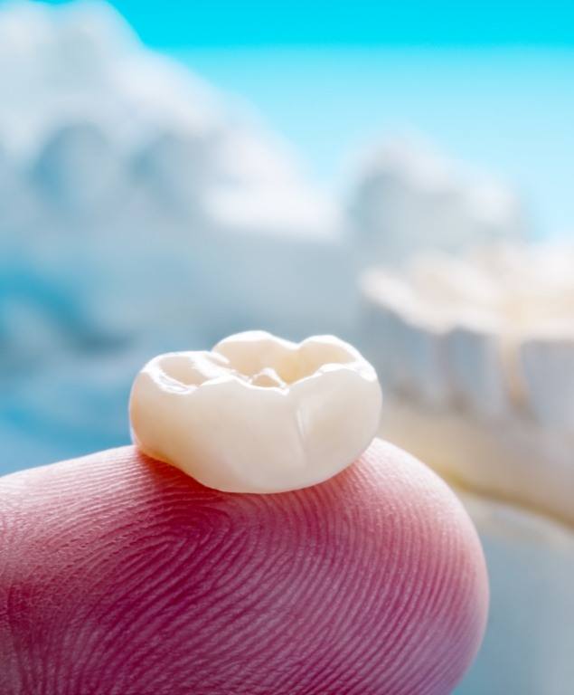 Dental crown resting on a finger