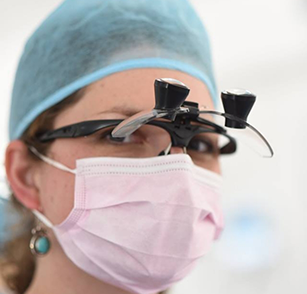 Dentist wearing mask and magnification glasses