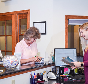 Team member and patient at reception desk