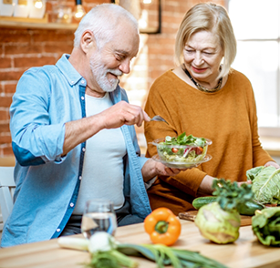 Older man and woman making a salad