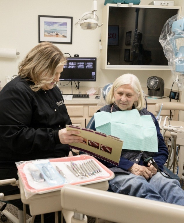 Dentist showing a folder to a patient