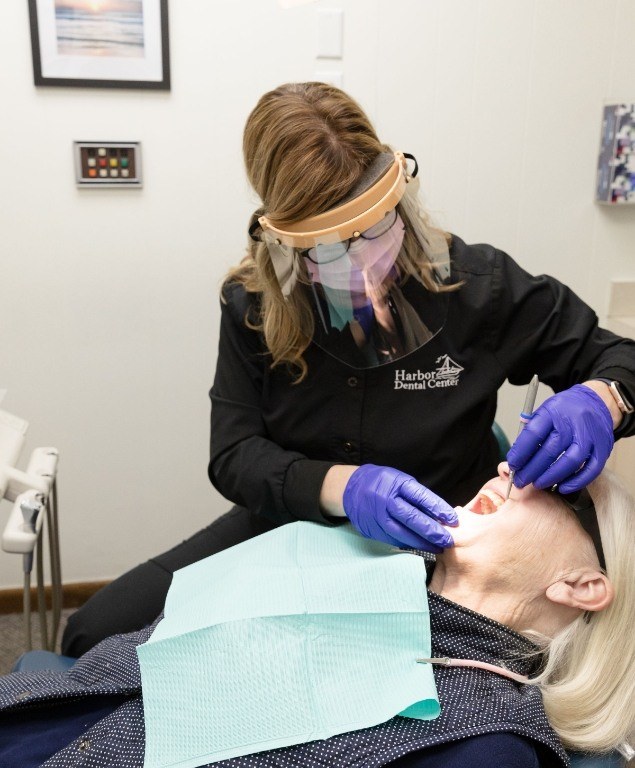 Dental hygienist giving a patient a teeth cleaning in Cambridge