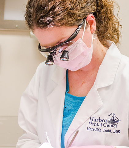 Close up of female dentist with mask and magnification glasses