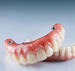 Two implant dentures sitting on blue surface