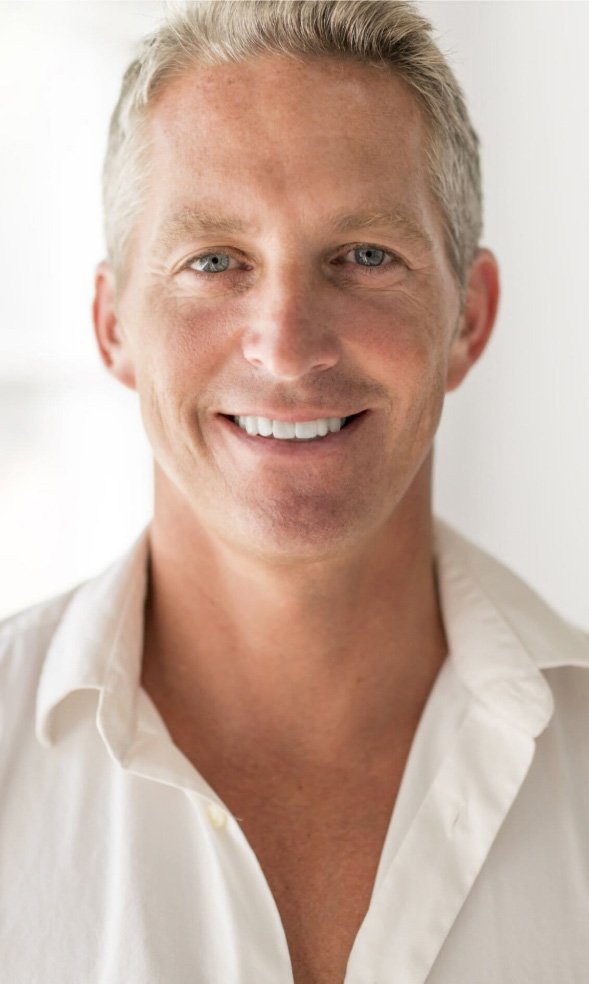 Smiling man in white collared shirt