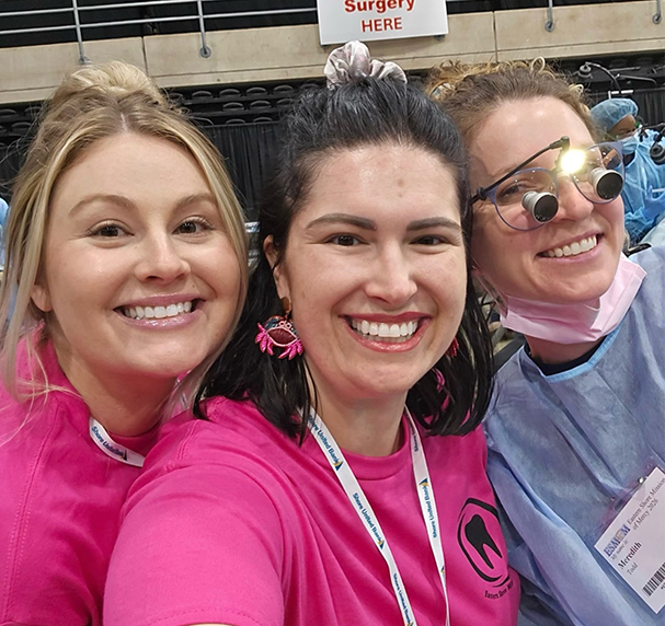 Three dental team members smiling