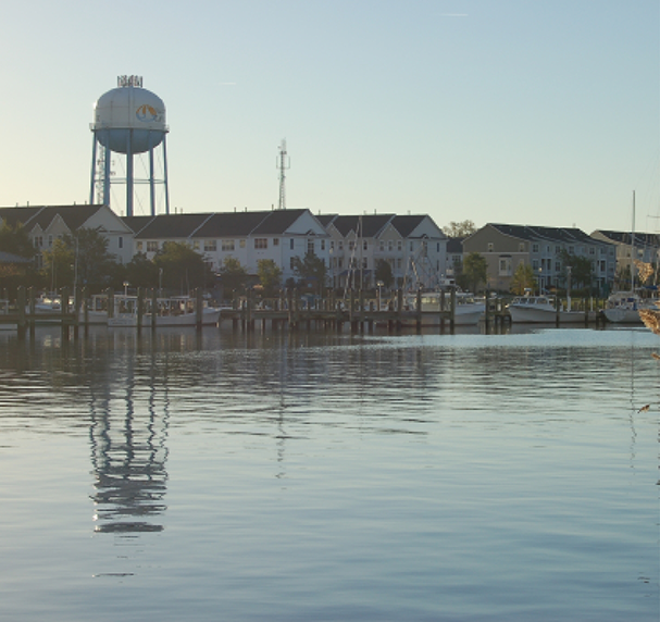 View of water tower and buildings from a lake