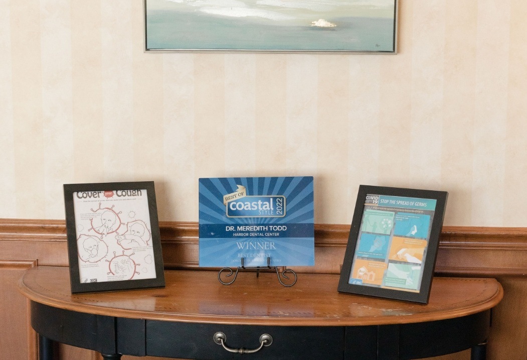 Small table with framed papers showing how to stop the spread of Covid