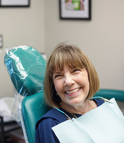 Woman sitting in dental chair and smiling