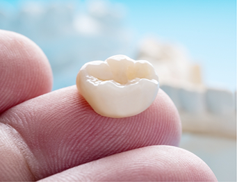 Close up of dental crown on finger