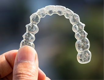 Holding clear aligners between finger and thumb