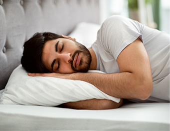 Bearded man lying down in bed to sleep