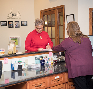 Female patient filling out form at reception desk