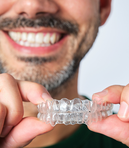 Older man holding clear aligners