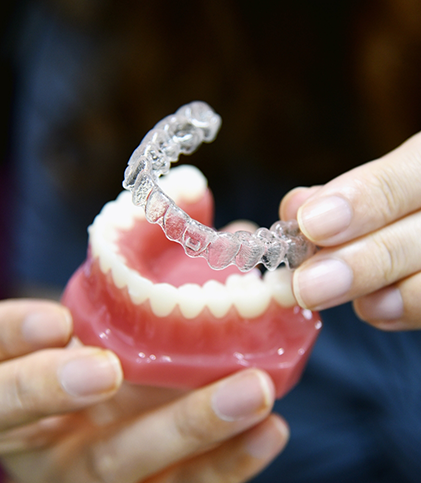 Taking clear aligners off model of teeth