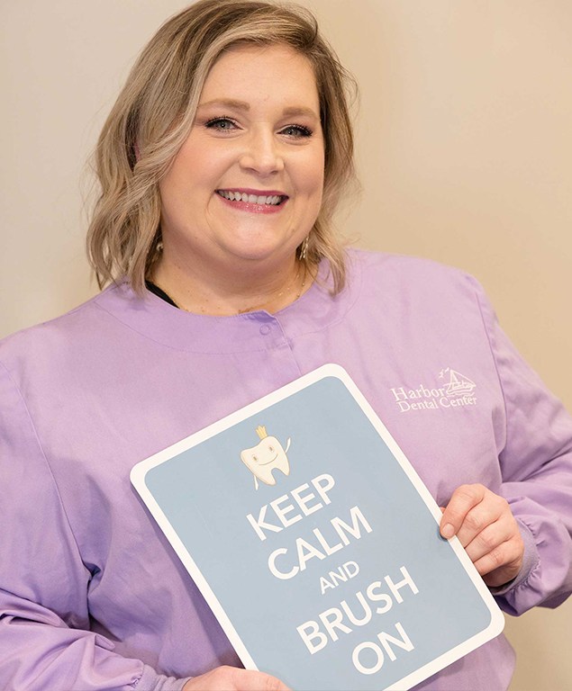 Jennifer holding sign that reads keep calm and brush on