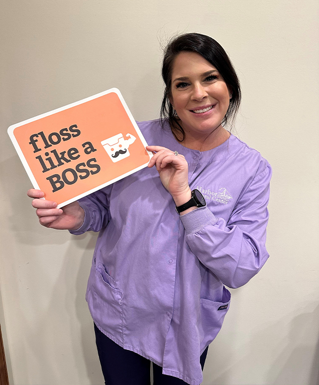 Mackenzie holding sign that reads floss like a boss