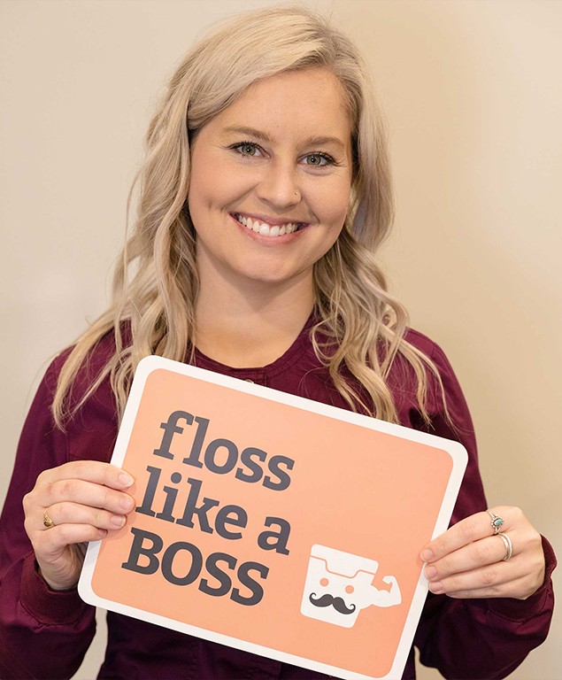 Megan holding sign that says floss like a boss