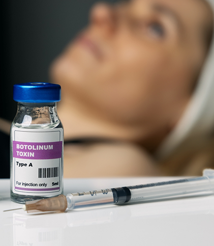 Bottle of botulinum toxin and needle in front of patient