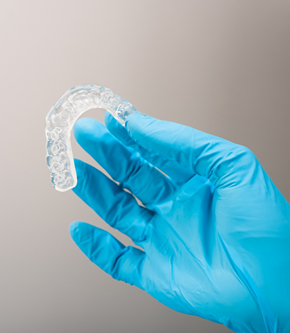 Gloved hand holding an occlusal splint