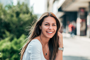 Close-up of woman with wavy hair smiling outside