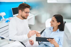dental staff member talking to female patient about insurance